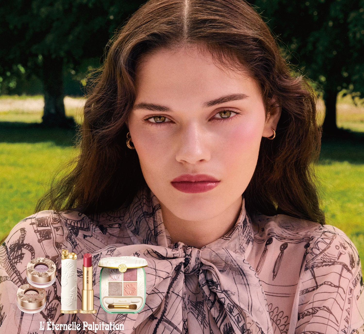 Woman in a park with Paul & Joe beauty products displayed